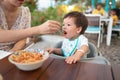 One year old baby boy having a meal in the restaurant with his mother Royalty Free Stock Photo