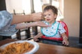 One year old baby boy having a meal in the restaurant with his mother Royalty Free Stock Photo