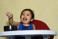 One 1 year old baby boy learning to eat alone smiling happy but messy Royalty Free Stock Photo