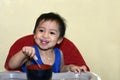 One 1 year old baby boy learning to eat alone smiling happy but messy Royalty Free Stock Photo