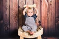 One year old baby boy sitting on chair in front of wooden background. One year concept with copy space Royalty Free Stock Photo