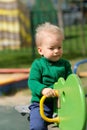 One year old baby boy toddler wearing green sweater at playground Royalty Free Stock Photo