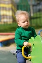 One year old baby boy toddler wearing green sweater at playground Royalty Free Stock Photo