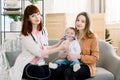 One year old baby girl getting a nebulizer treatment from a doctor. breathing through a steam nebulizer. concept of