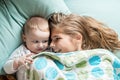 One year old baby lying in bed with a plush teddy bear Royalty Free Stock Photo