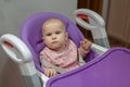 One-year-old baby sitting in a purple chair in the kitchen Royalty Free Stock Photo