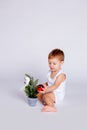 One year old baby tries to decorate the Christmas tree with a Christmas toy