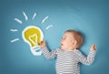 One year old boy and a bulb near. Child with an idea Royalty Free Stock Photo