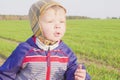One year old boy farmer going in the field with young wheat. Closeup Royalty Free Stock Photo