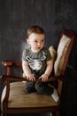 The one-year-old boy is gaming on a armchair