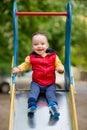 One-year-old boy plays on a playground next to a slide. Royalty Free Stock Photo