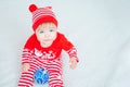 A one-year-old cute child in a red and white Christmas costume plays with a blue Christmas ball. Beautiful Caucasian Royalty Free Stock Photo