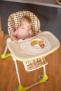 One year old girl having balanced meal in baby eating chair, healthy balanced nutrition for child Royalty Free Stock Photo