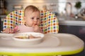 One year old girl having balanced meal in baby eating chair, healthy balanced nutrition for child Royalty Free Stock Photo