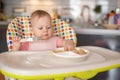 One year old girl having balanced meal in baby eating chair, healthy balanced nutrition for child Royalty Free Stock Photo