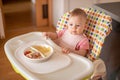 One year old girl having balanced meal in baby eating chair, healthy balanced nutrition for child Royalty Free Stock Photo