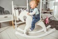 One-year-old girl playing near in the room with a toy horse, ska Royalty Free Stock Photo