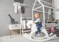 One year old girl playing near in the room with a toy horse, ska Royalty Free Stock Photo