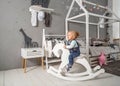 One year old girl playing near in the room with a toy horse, ska Royalty Free Stock Photo