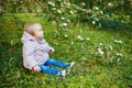 One year old girl sitting on the grass under tree branch Royalty Free Stock Photo