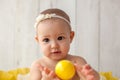 One year old girl sitting in handmade paper green cabbage. Portrait. Royalty Free Stock Photo