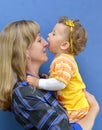 One-year-old girl tries to bite her mother by the nose Royalty Free Stock Photo