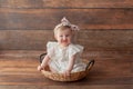 One year old girl in wicker basket. With headband. Royalty Free Stock Photo