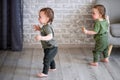 One year old  twin boys are standing near the sofa Royalty Free Stock Photo