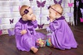 One-year-old twins on the birthday. Cute twin sisters celebrating their 1th birthday. Little twins girl siting on a floor and Royalty Free Stock Photo