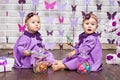 One-year-old twins on the birthday. Cute twin sisters celebrating their 1th birthday. Little twins girl siting on a floor and Royalty Free Stock Photo