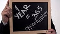 One year is 365 opportunities motivation on blackboard in businessman hands