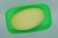 One yellow bar of soap lies in an open green plastic soap dish Royalty Free Stock Photo