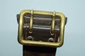 One yellow copper buckle on an old leather brown army belt Royalty Free Stock Photo