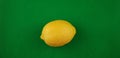 One yellow fresh lemon on green background Royalty Free Stock Photo