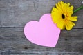 One yellow gerbera flower with pink paper heart on wood Royalty Free Stock Photo