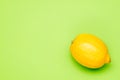 One yellow lemon on a green background Royalty Free Stock Photo