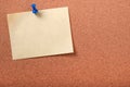 One yellow sticky post note pinned pushpin cork background Royalty Free Stock Photo