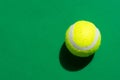 One yellow tennis ball laying on green court in bright sunlight sports active lifestyle competition victory concentration concept Royalty Free Stock Photo