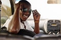 One young african american man wearing stylish sunglasses while driving in a car during a road trip. Happy black male Royalty Free Stock Photo