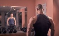 One young bodybuilder back looking in mirror, looking at self, r