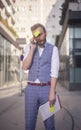 One young businessman talking on a phone, while post-it note is comically attached to his forehead Royalty Free Stock Photo