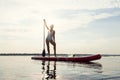 One young Caucasian beautiful slim girl sunbathe on summer evening on river on paddle board, SUP alone. Active life Royalty Free Stock Photo