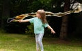 One young child, little girl making huge soap bubbles in the garden. Active kid in the backyard, green park blowing large bubbles Royalty Free Stock Photo