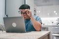 One young confused man looking at laptop without understanding homework or work. Teenager boy using computer at home sitting at Royalty Free Stock Photo