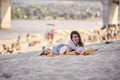 One young girl, relaxing reading a book outdoors, beach Royalty Free Stock Photo