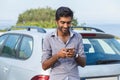 One young handsome Indian man smiling holding looking at mobile phone Royalty Free Stock Photo