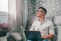 One young happy man surfing the net using his laptop at home sitting on the sofa enjoying free time and relaxing alone. Royalty Free Stock Photo