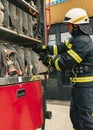 One young male firefighter dressed in uniform with protective helmet near fire engine.