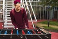 One young man in casual clothes playing foosball in the public park. table games concept Royalty Free Stock Photo