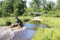 Man driving motocross ATV quad through splashing river lake water. Foy, Sudbury, Ontario, Canada. Royalty Free Stock Photo